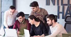 A Diverse Group Of Professionals Collaborating On Laptops In A Modern Office Environment.
